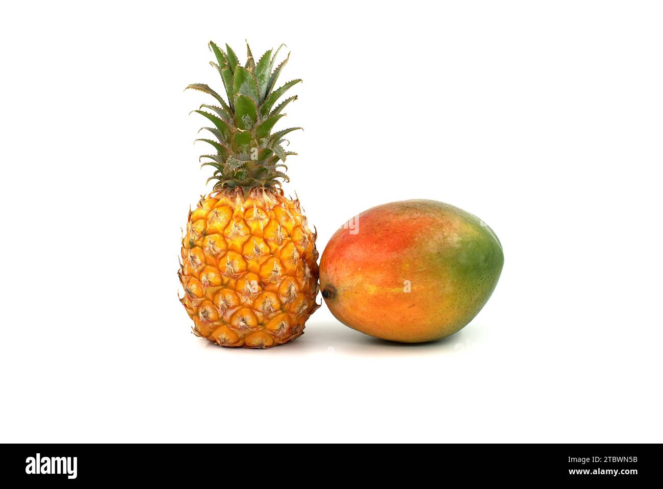 Whole pineapple fruit and multicolored mango isolated on a white background Stock Photo