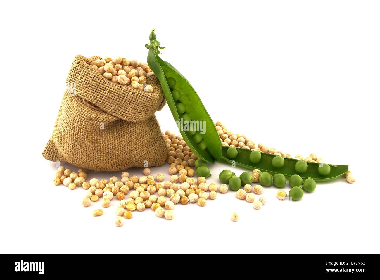 Dried whole peas spilling from a hessian bag near fresh harvest green