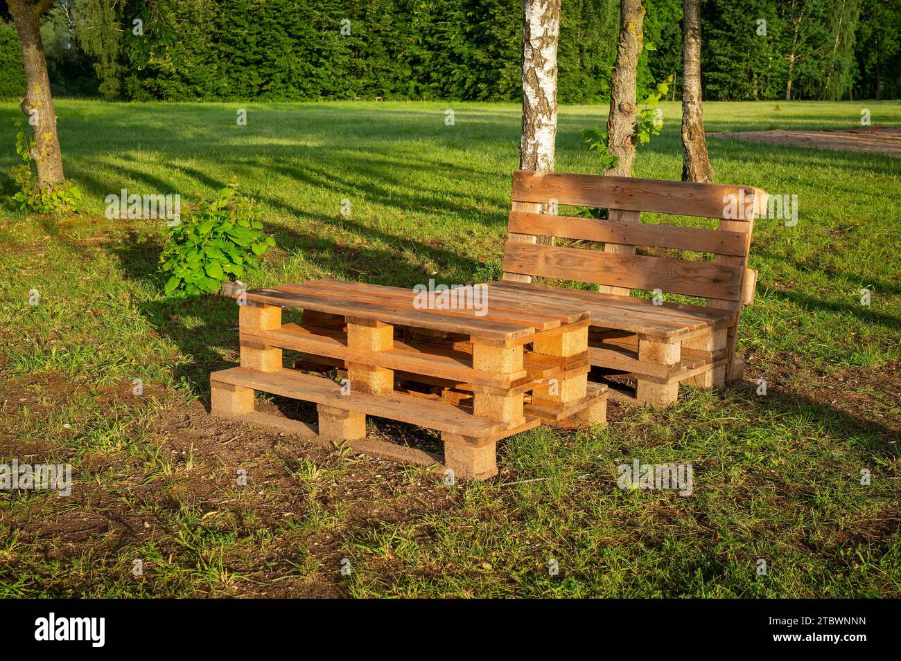 Outdoor furniture made from wood pallets surrounded by trees and