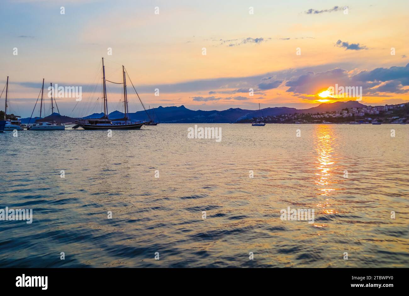 Beautiful Mediterranean coast with islands, mountains and yachts at sunset Stock Photo