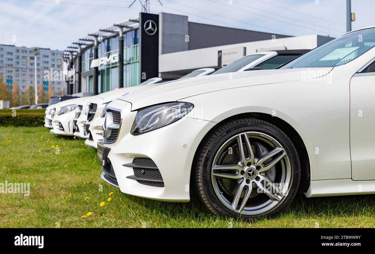 A picture of a row of white vehicles at a Mercedes Benz car dealership