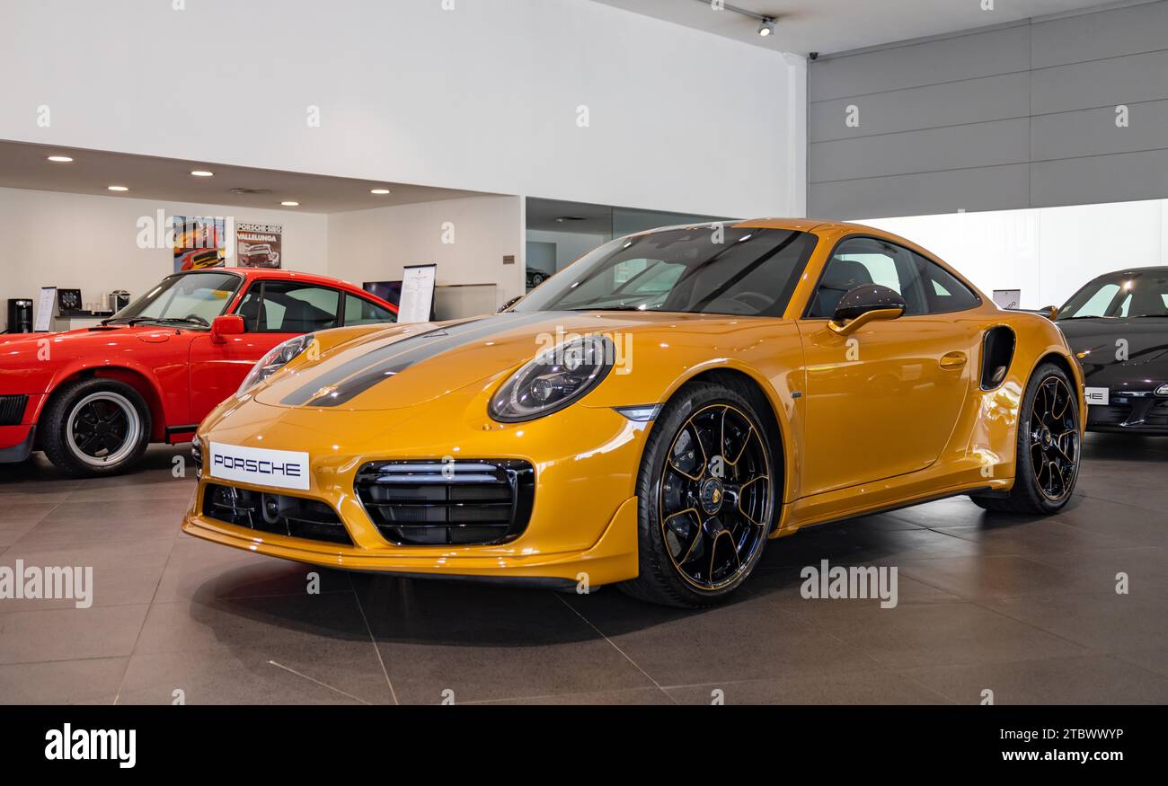 A picture of an orange Porsche 911 Turbo S inside a dealership Stock