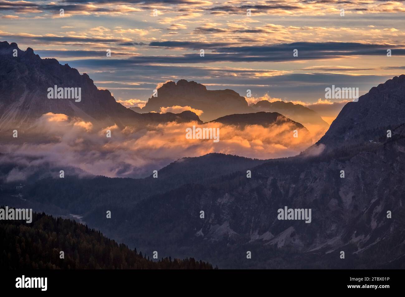 The rock formation Croda da Campo in the distance, the valley covered in clouds at sunrise in autumn, seen from Passo Falzarego. Stock Photo
