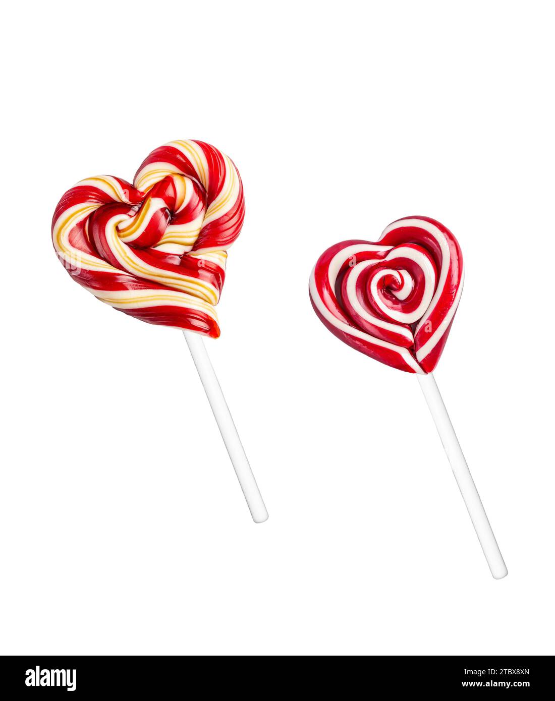 Two Types of Heart Shaped Red and White Swirl Lollipops on White Backdrop Stock Photo