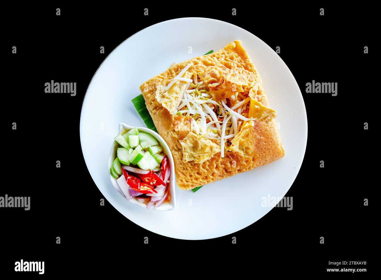 Die cut of Thai Crispy Pancake (Kanom Buang)Vietnamese stuffed crispy omelette. with sliced cucumber,chillies sweet-sour vinegar on black isolated. Stock Photo