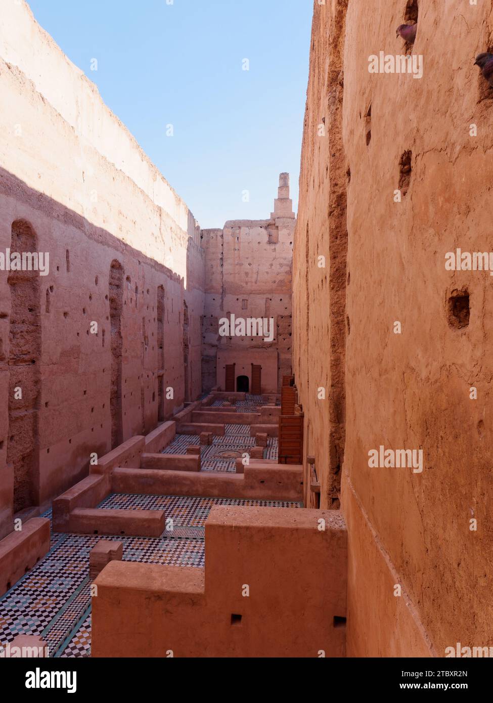Courtyard with high earthen walls with tiled floors in Badi Palace as birds stick heads out. Marrakesh aka Marrakech, Morocco, December 09, 2023 Stock Photo