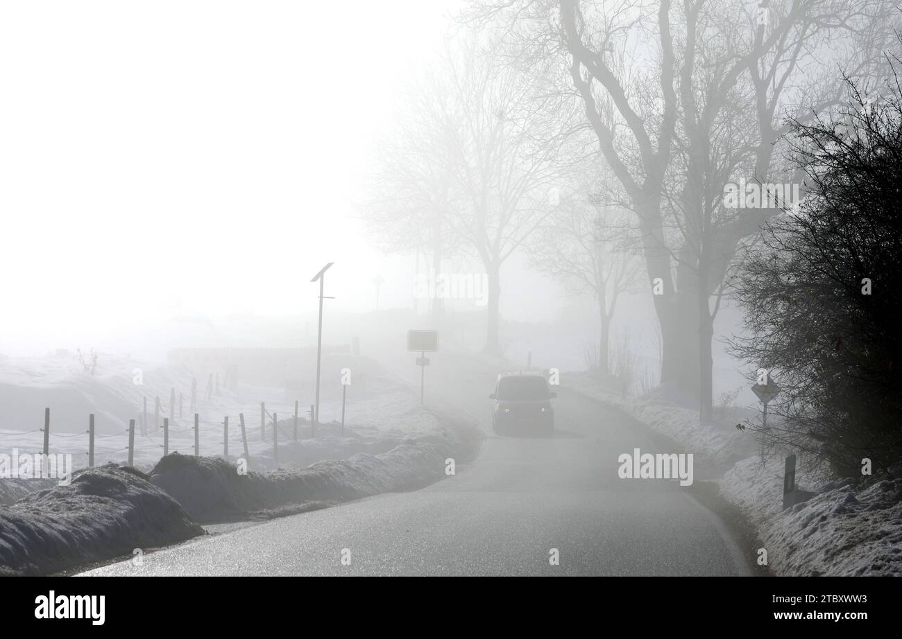 Rettenbach, Germany. 09th Dec, 2023. A car drives through the fog in the wintry landscape. Credit: Karl-Josef Hildenbrand/dpa/Alamy Live News Stock Photo