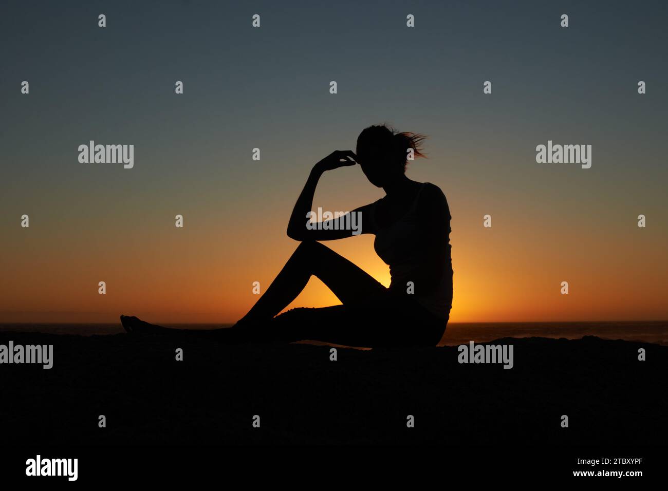 Sunset, silhouette and woman at a beach relax, resting and enjoying ...
