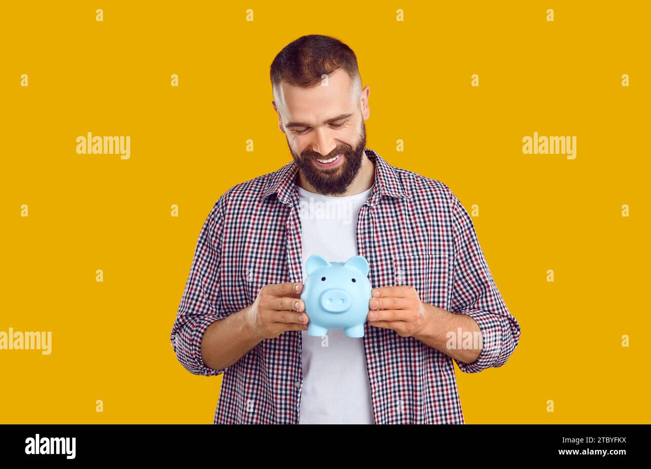 Happy handsome young man holding his piggy bank Stock Photo - Alamy