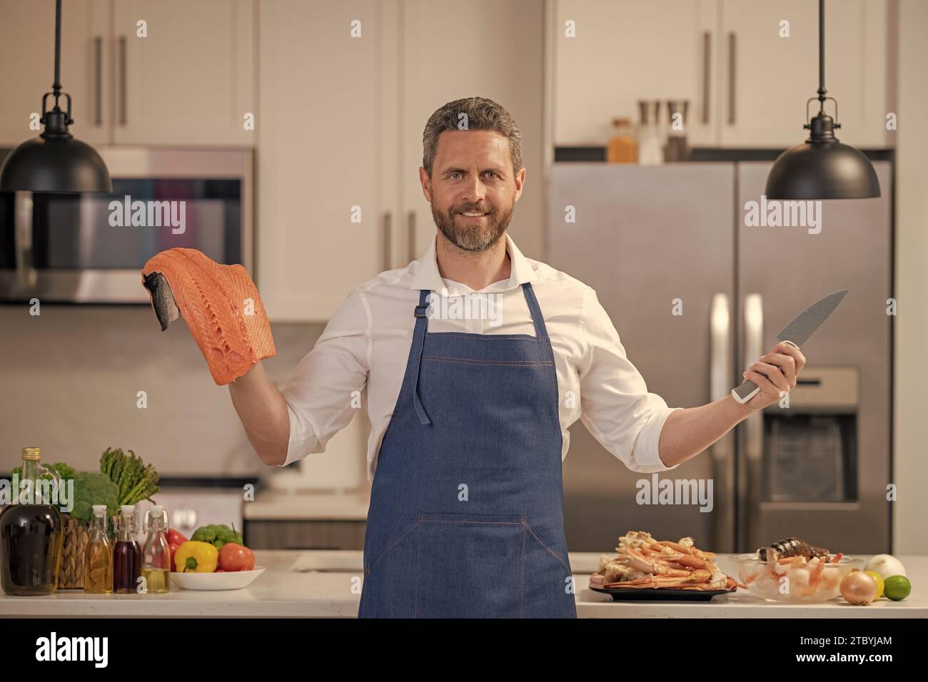 happy man cook delicacy salmon fish. man cook delicacy salmon in the k ...