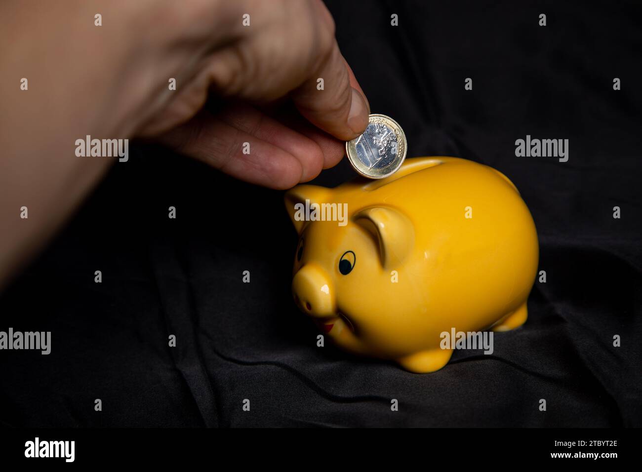 Ein Euro in eine Sparschwein stecken Stock Photo