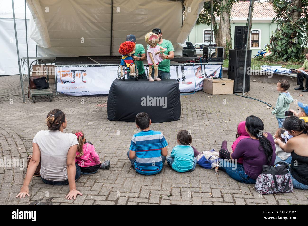 Young kids with mothers watching a puppet show In a park (Morazan Park