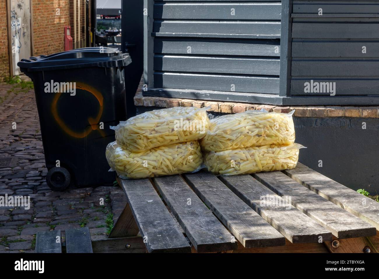 Defrost french fries outside on a table without any respect of the cold channel. | Frites degelant en exterieur au soleil sans aucun respect de la cha Stock Photo