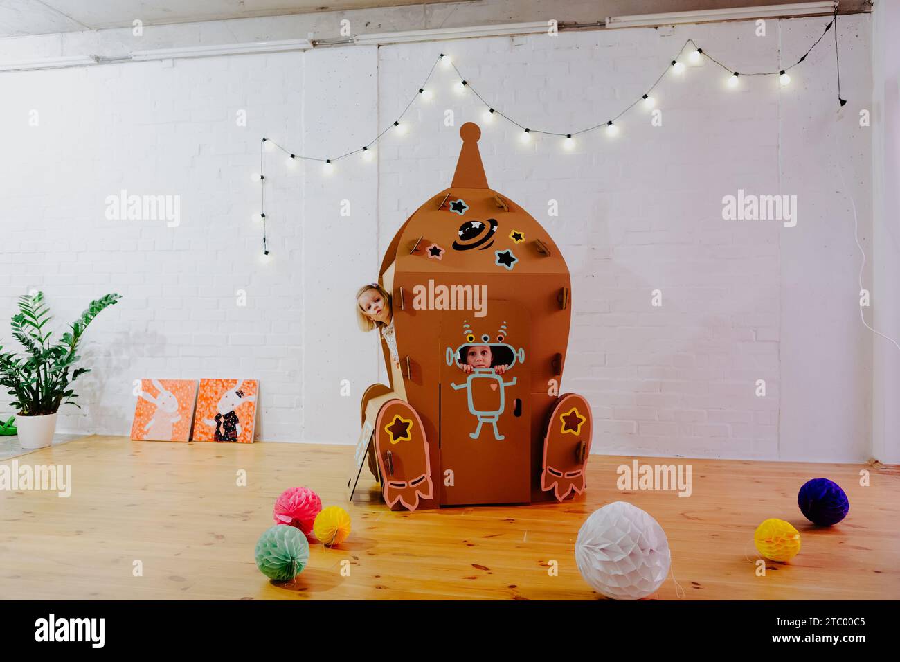 Joyful girl playing in cardboard rocket Stock Photo - Alamy