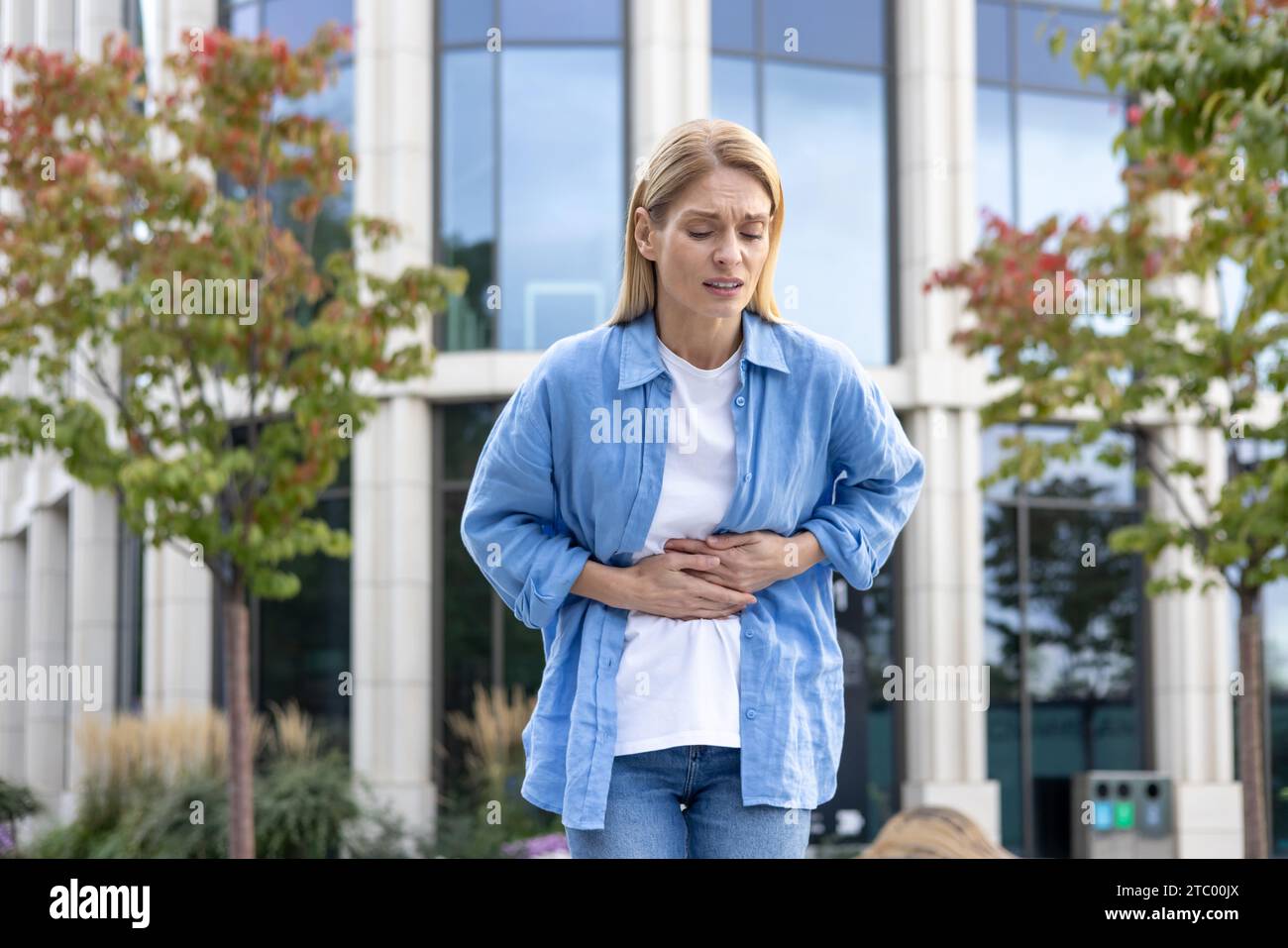 Sick businesswoman stomach ill blonde hi-res stock photography and ...