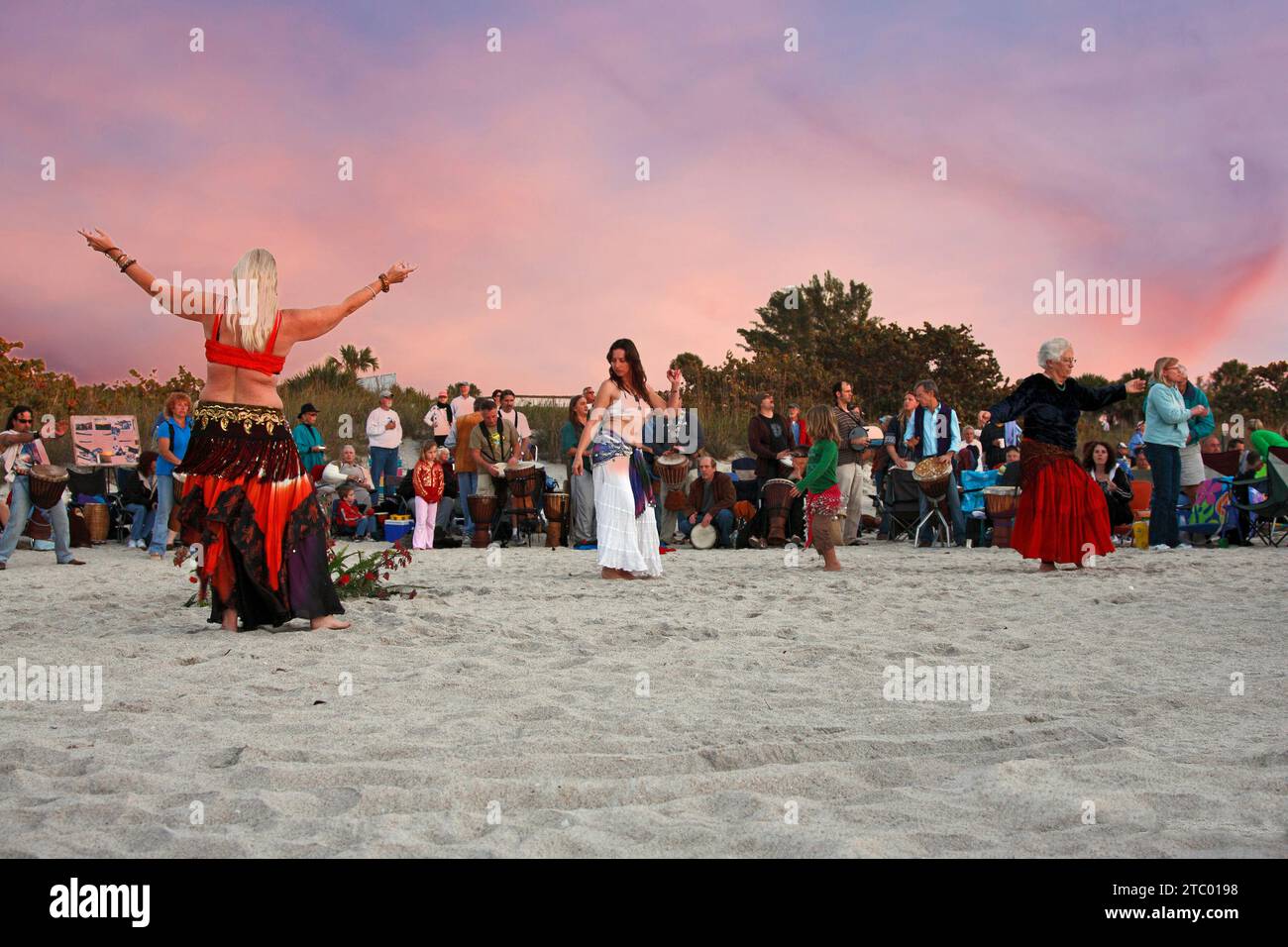 belly dancers & drummers, on sand beach; spectators; musicians; entertainment; sunset celebration; Nokomis; FL; Florida; winter Stock Photo