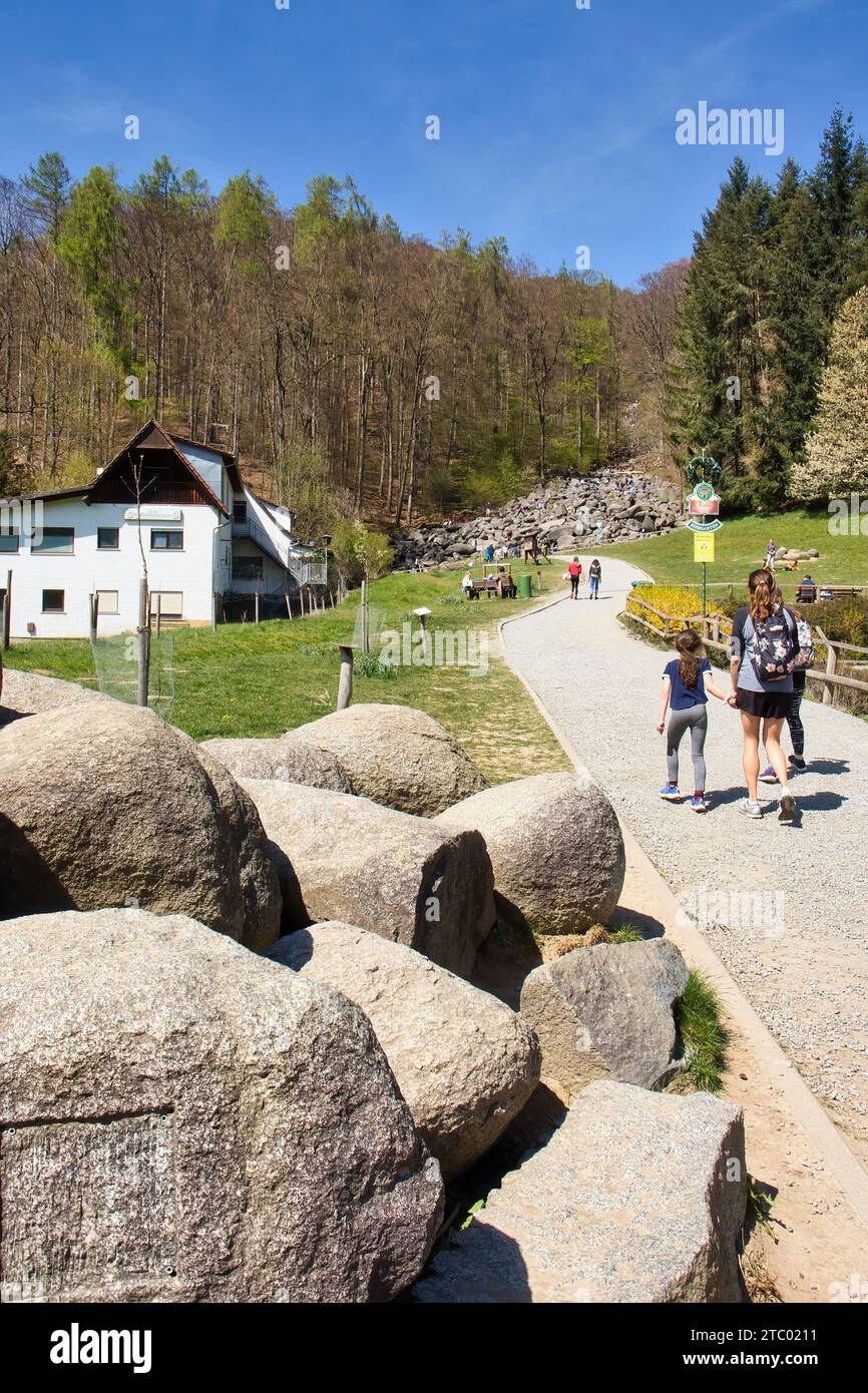 Lautertal, Germany - April 24, 2021: People walking on a path leading to Felsenmeer, Sea of Rocks, on a spring day in Germany Stock Photo