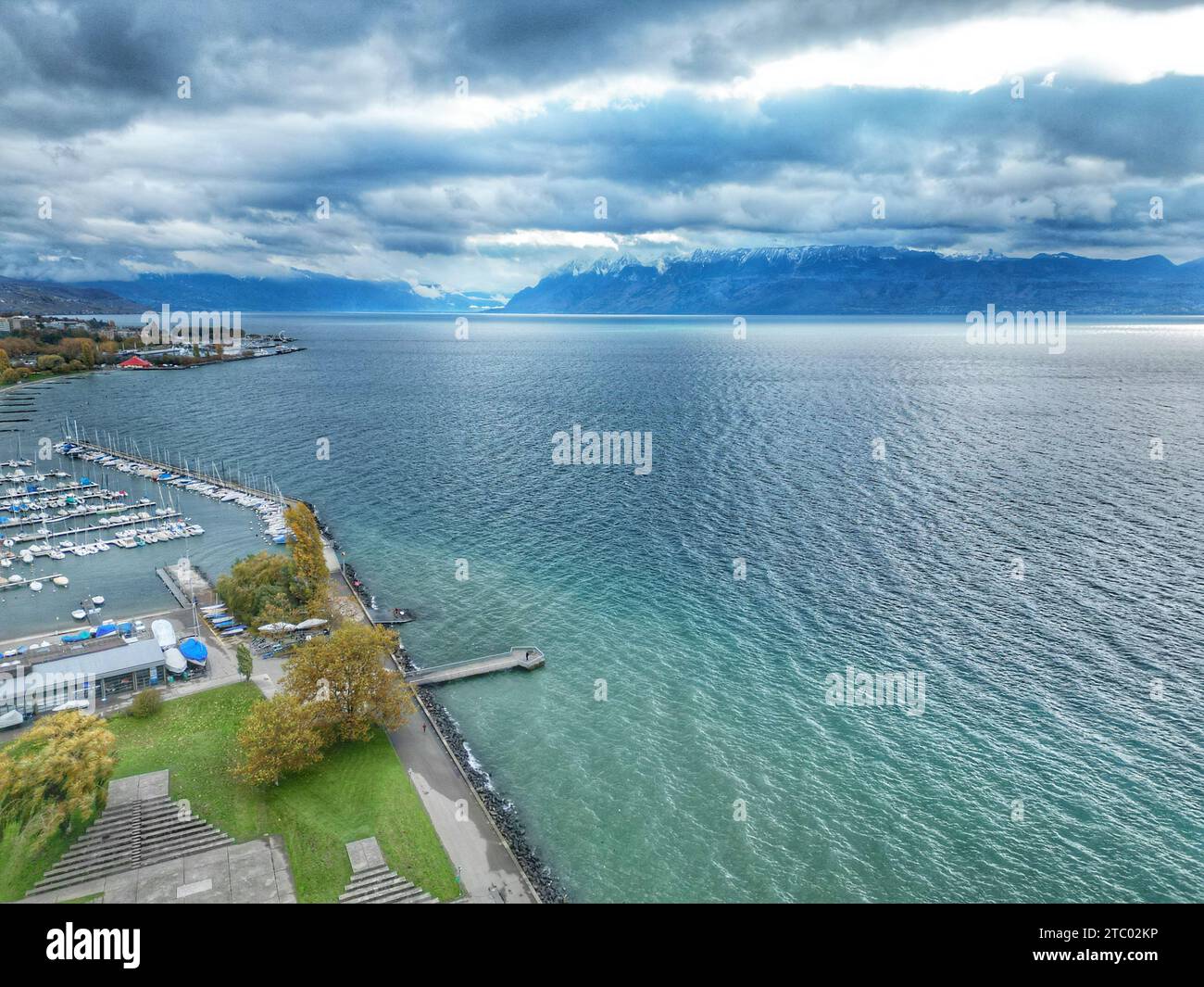 An aerial view of boats docked at a harbor against the blue sea under a ...