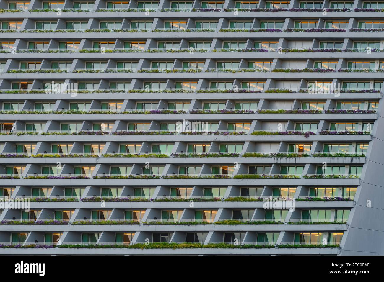 A modern-style building with multiple windows and grassy balconies in Singapore Stock Photo