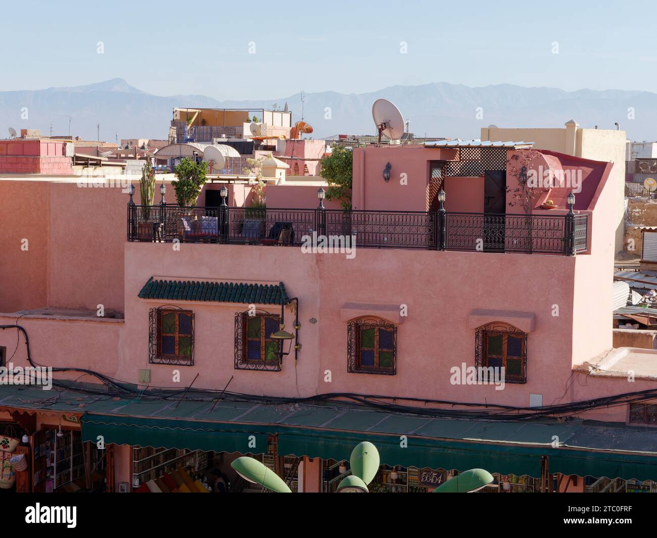 Elevated cityscape view across the rooftops with satellite dishes in Marrakesh aka Marrakech with mountains behind, Morocco, December 09, 2023 Stock Photo