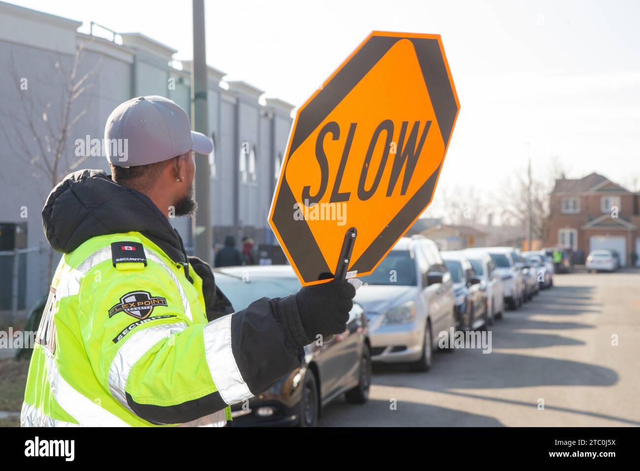 Security guard conducting access control and traffic control around a community building. Stock Photo