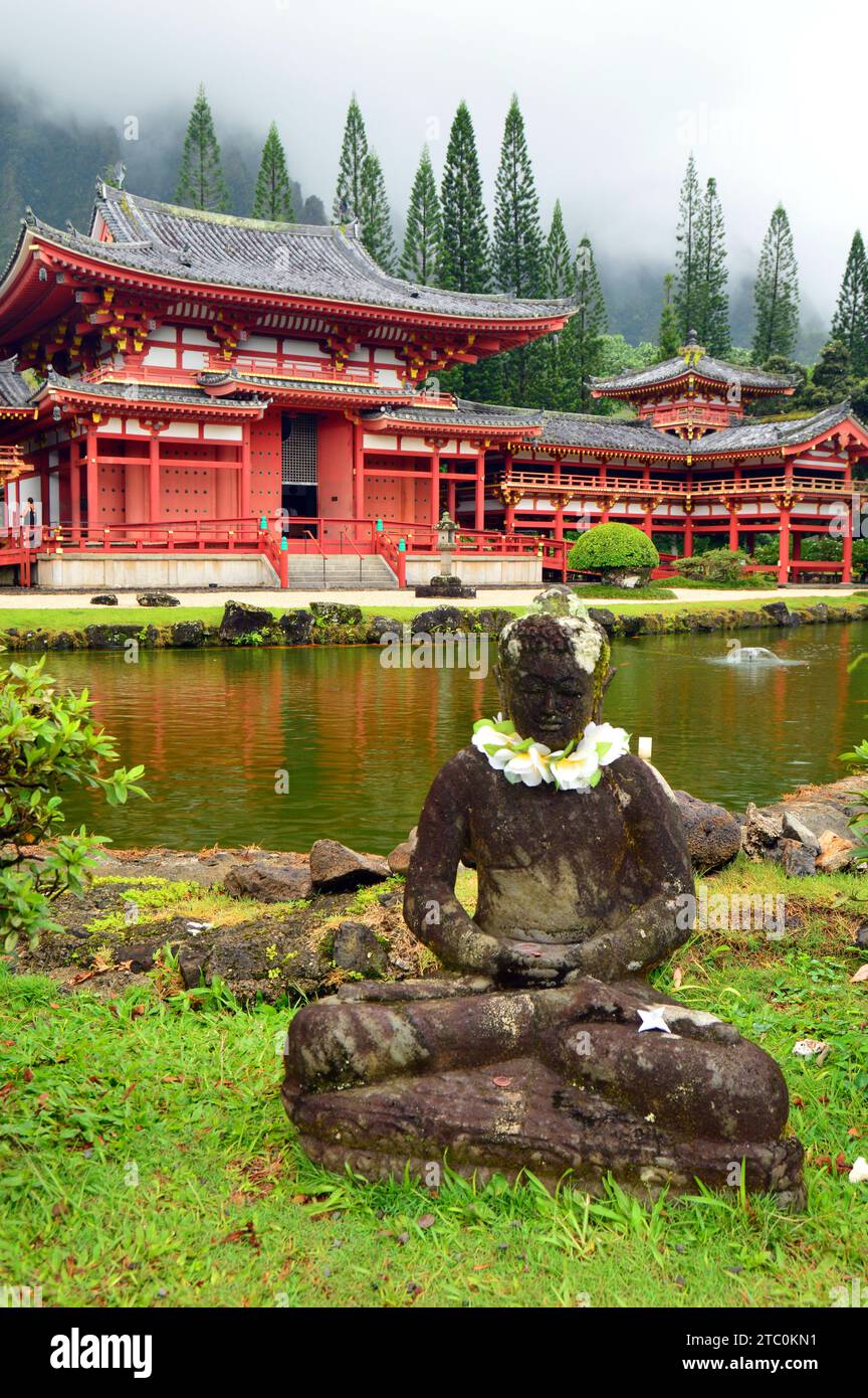 A statue is adorned with leis at Hawaii’s Byodo-In temple, A Japanese and Asian house or worship in Hawaii Stock Photo