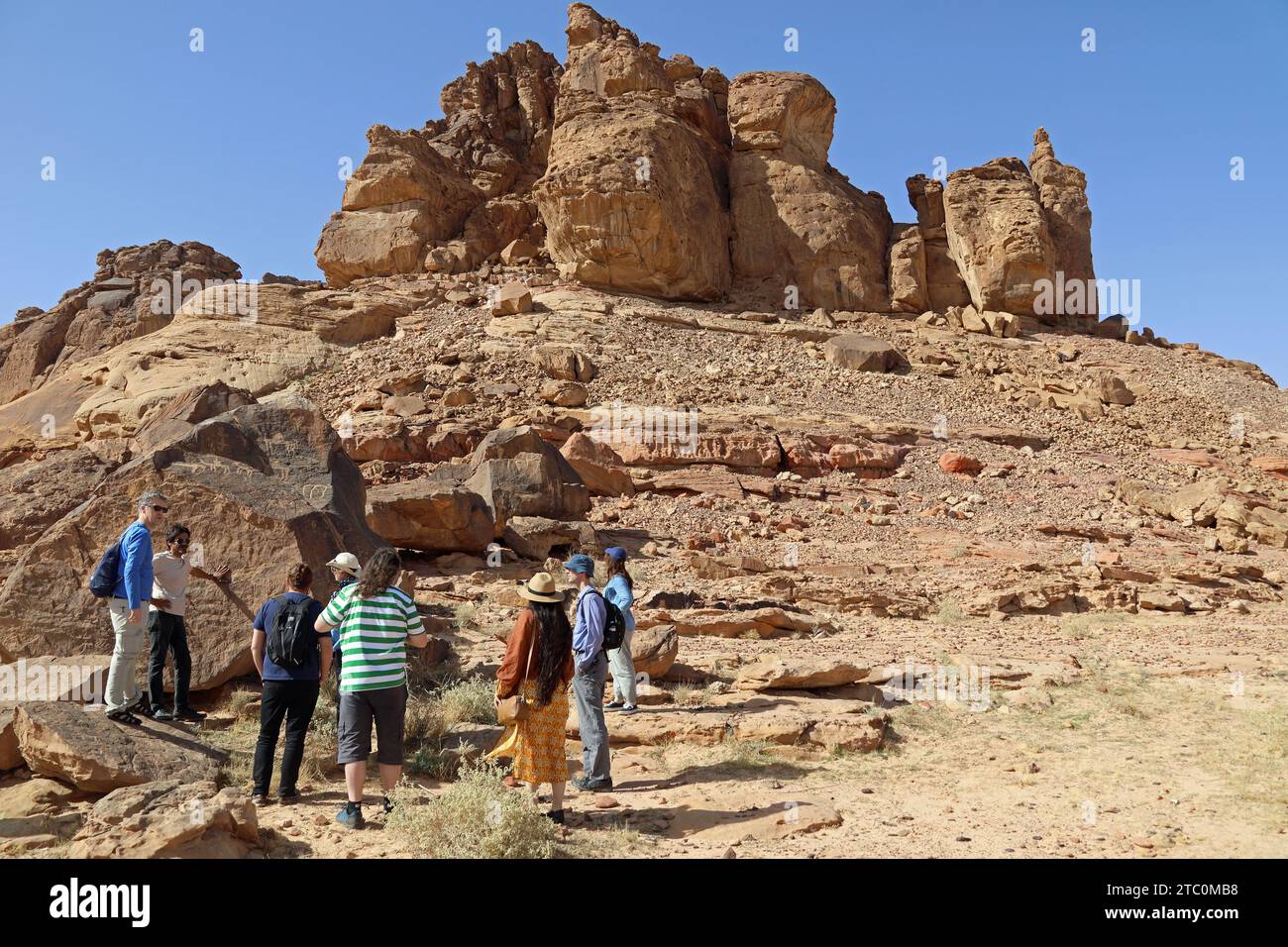 Tourists finding petroglyphs at Umm Sinman Mountain in the Great Narfoud Desert of Saudi Arabia Stock Photo