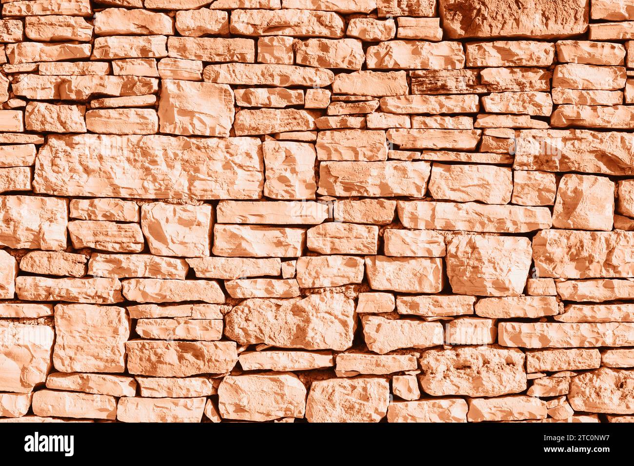 Old grunge stone masonry background, texture. Demonstrating color of the year 2024 Peach Fuzz. Stock Photo