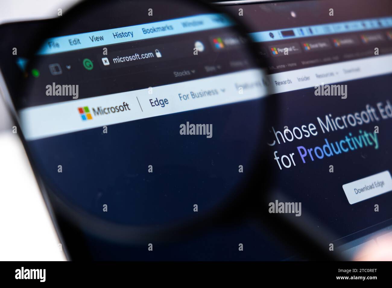 Microsoft Edge logo on the screen of laptop through magnifying glass, December 2023, Prague, Czech Republic Stock Photo