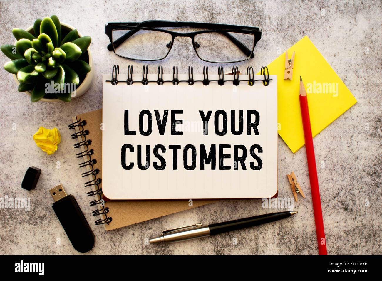 text LOVE YOUR CUSTOMERS on white paper. Stock Photo