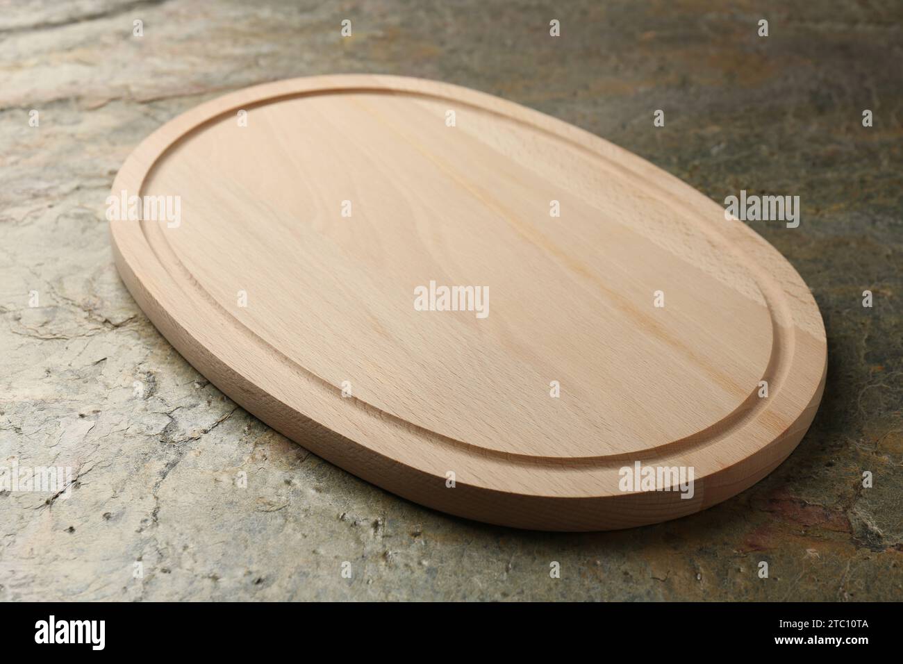 Wooden cutting board on textured table, closeup Stock Photo