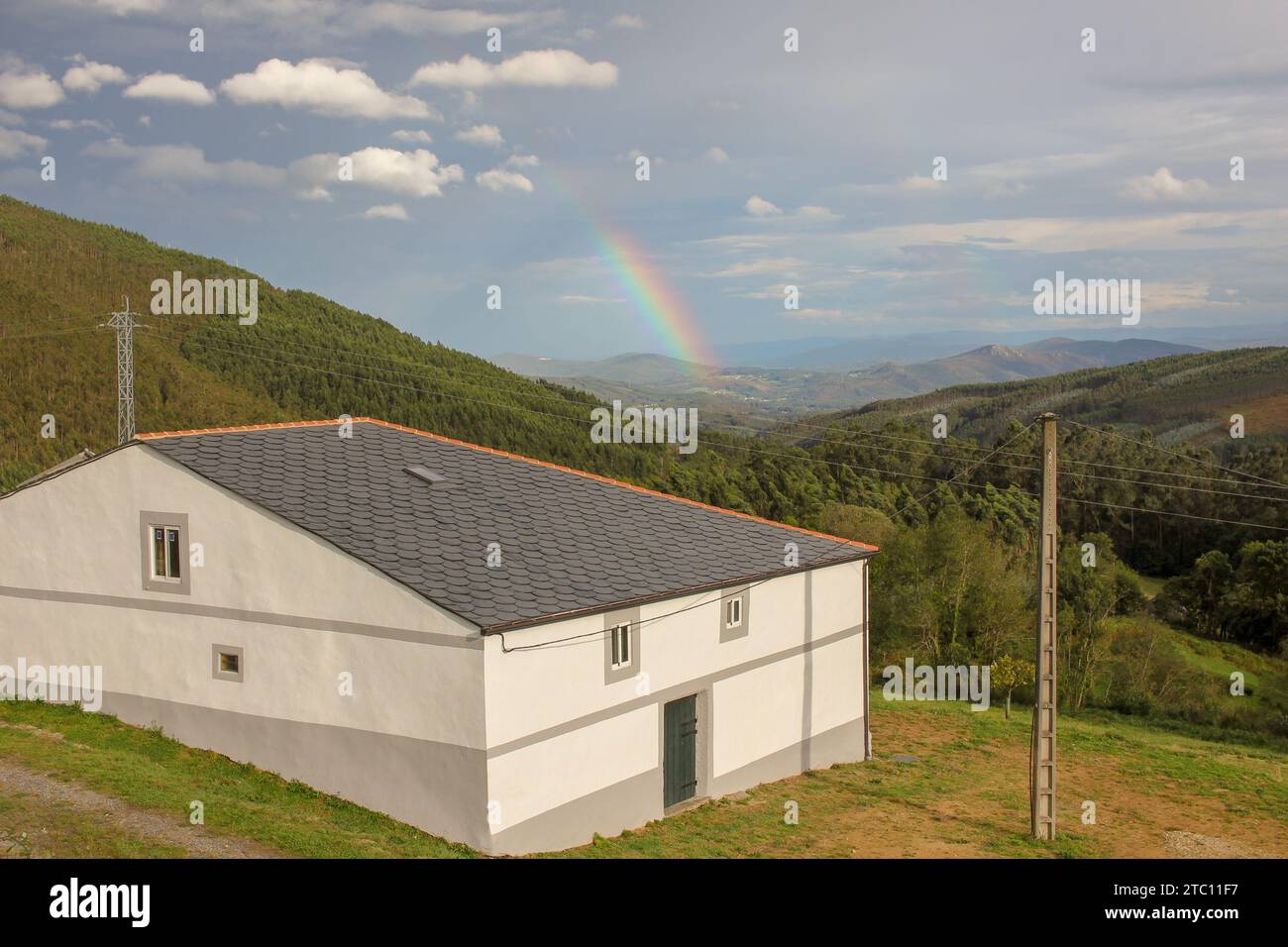 Serenity at Home: Rainbow Over Green Hills and White House Stock Photo