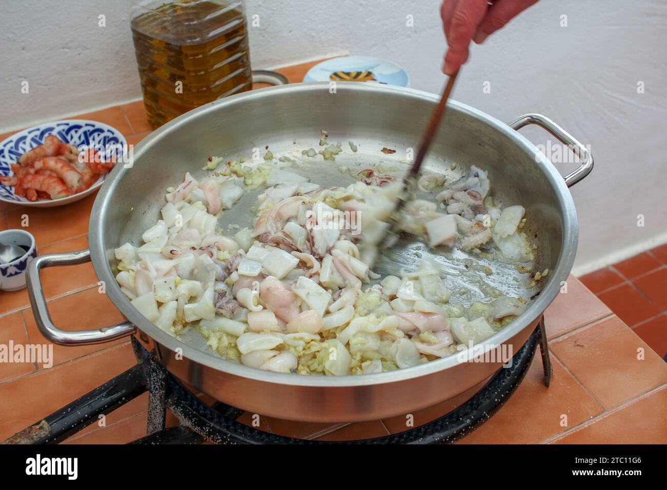 Culinary Creation: Hand Stirring a Delectable Squid Ink Risotto Stock Photo