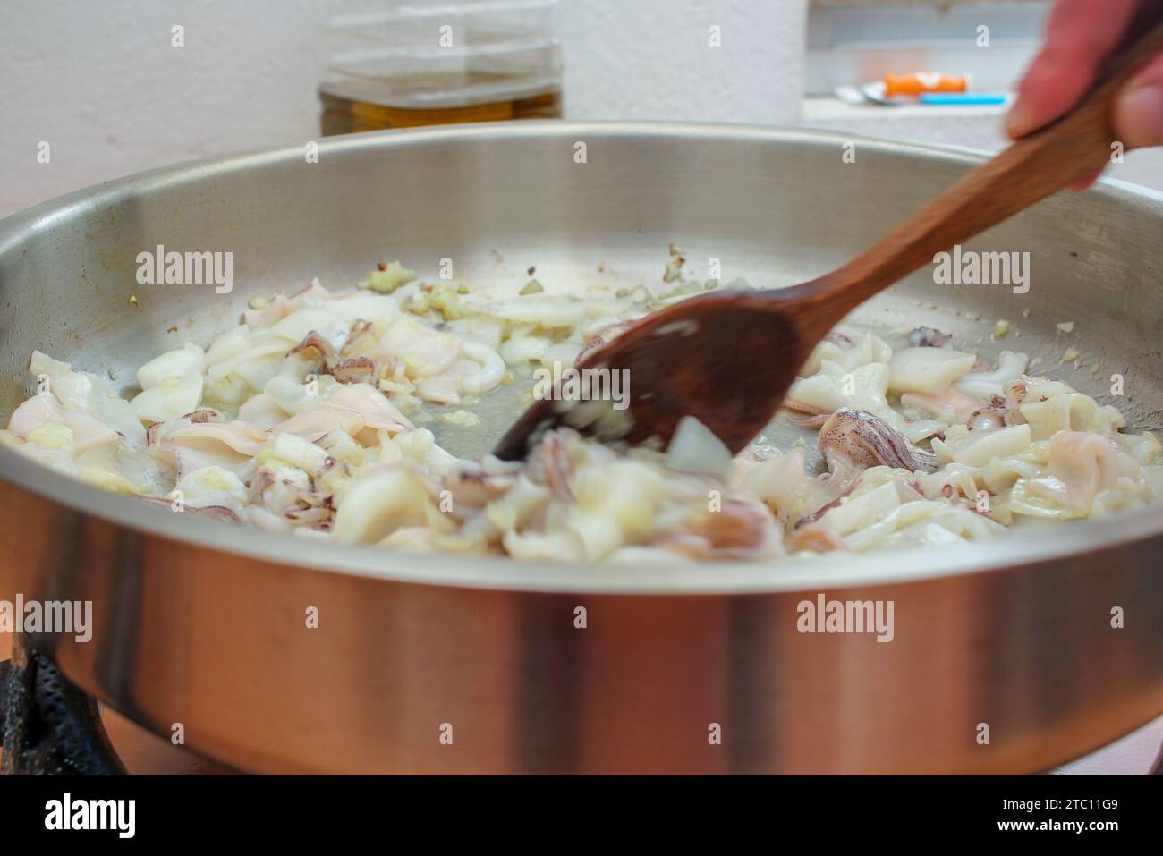 Culinary Creation: Hand Stirring a Delectable Squid Ink Risotto Stock Photo