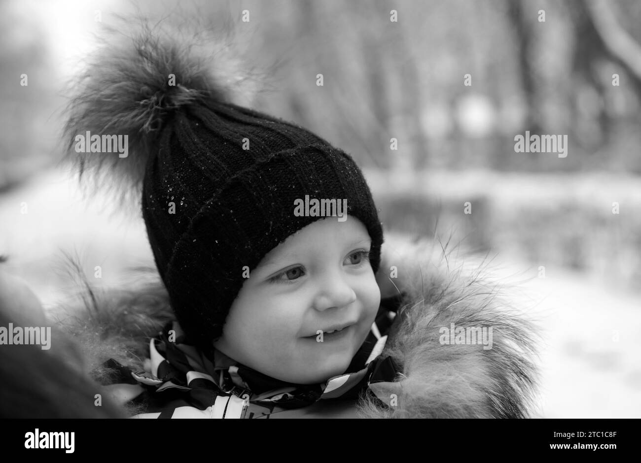 Funny laughing baby in winter outside. Cute toddler kid in a warm