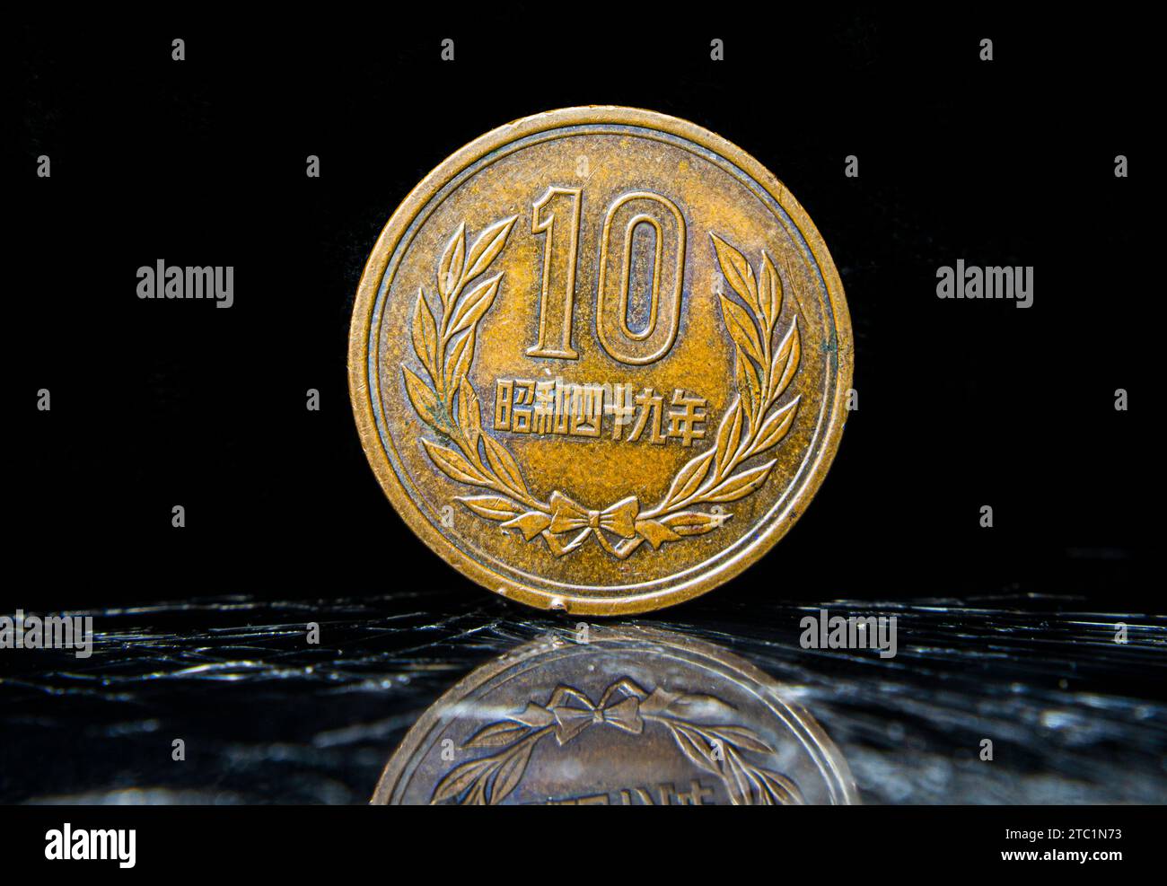 An aged penny sitting atop a table, displaying 10 Yen - Heisei, Japanese coin Stock Photo