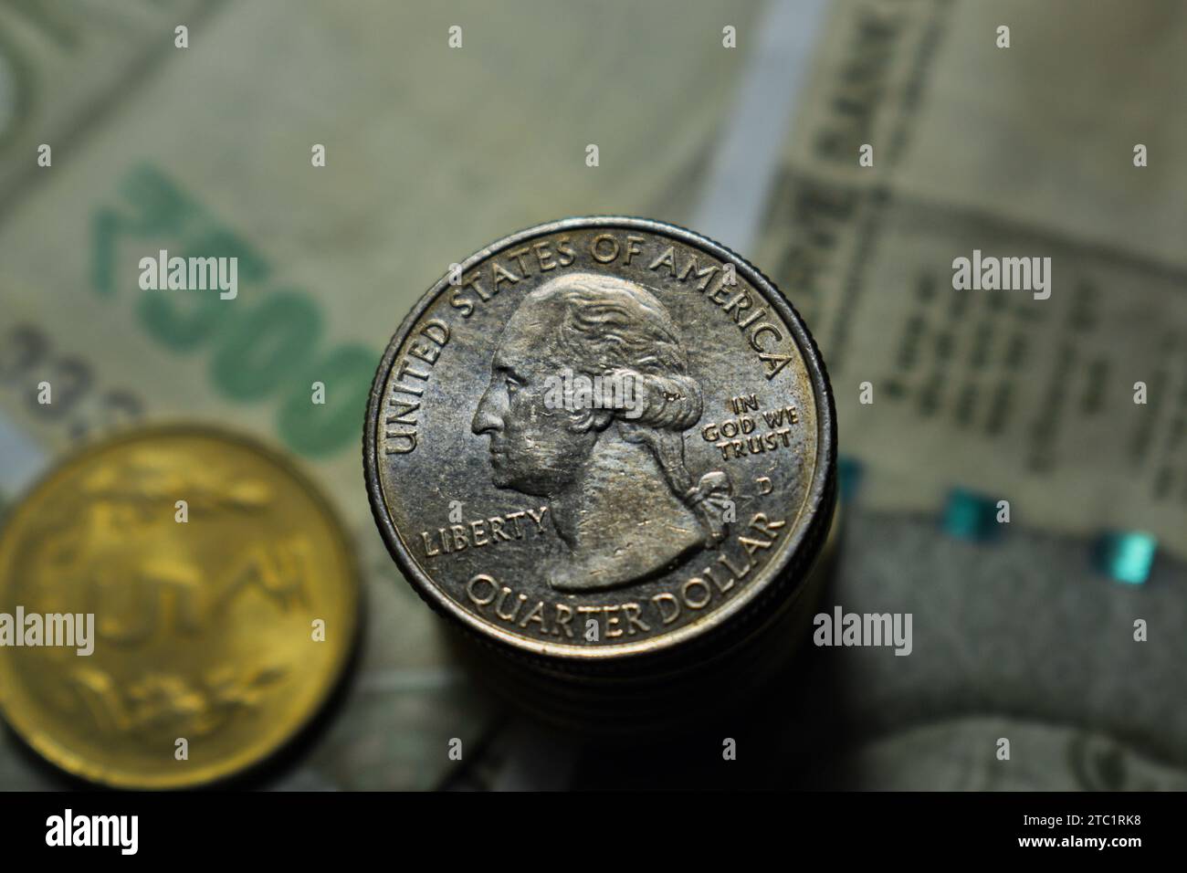 US Quarter dollar is stacked under Indian currency of five hundred