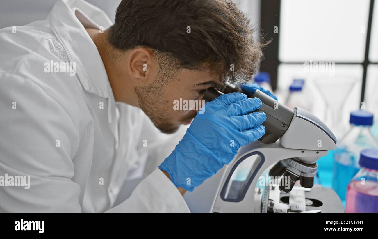 Young arab man scientist using microscope at laboratory Stock Photo