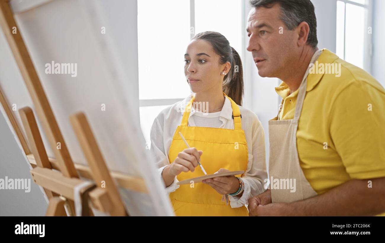 In an art studio, a man and woman artists passionately drawing together ...