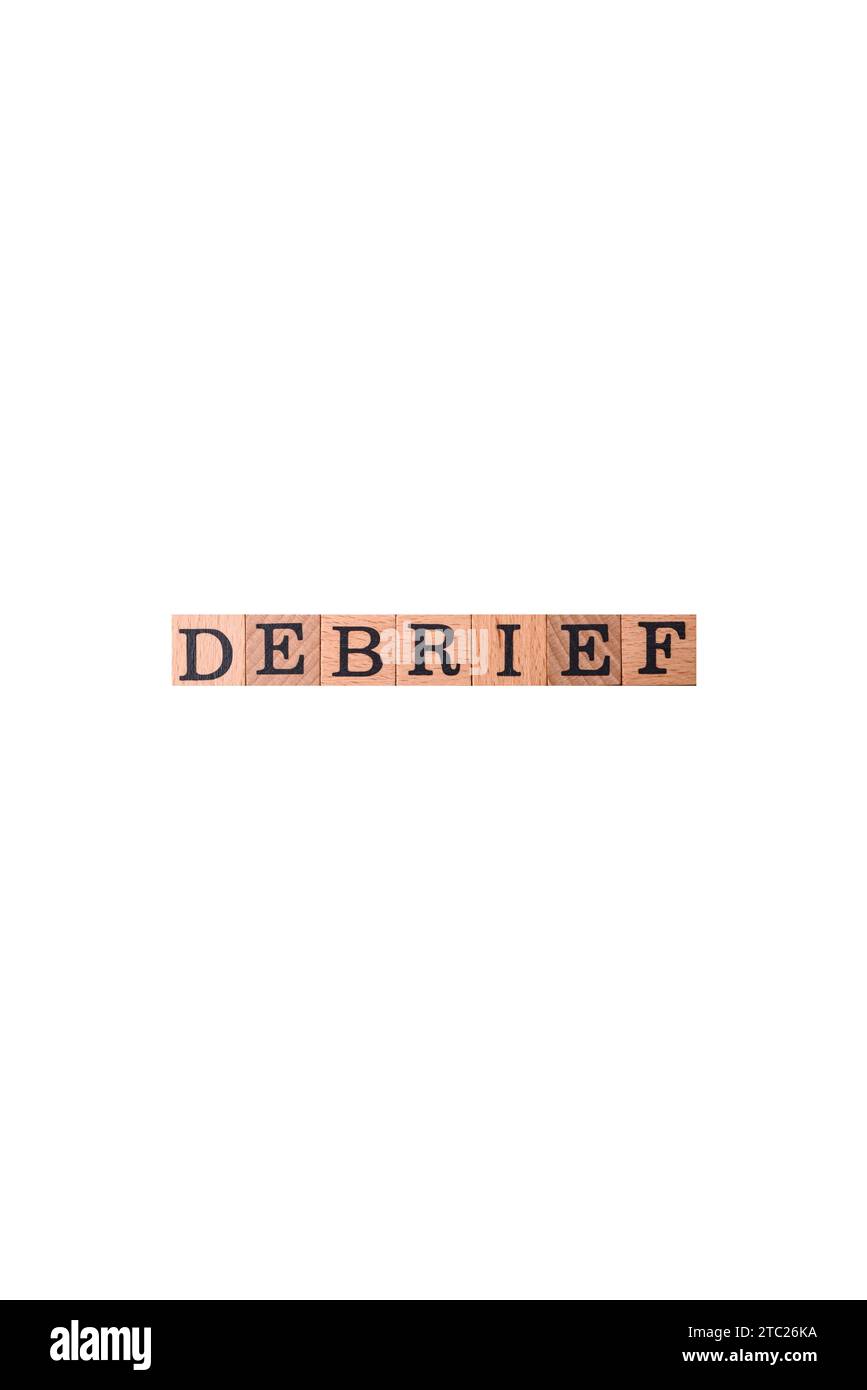 The inscription debrief in wooden cubes on a dark concrete background. Can be used as part of your composition Stock Photo