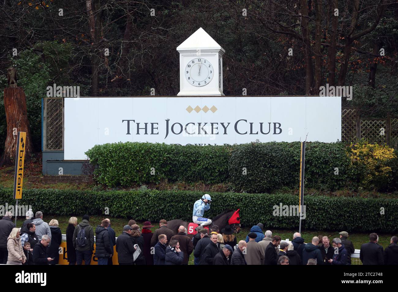Racegoers watch runners and riders head to the course during day two of