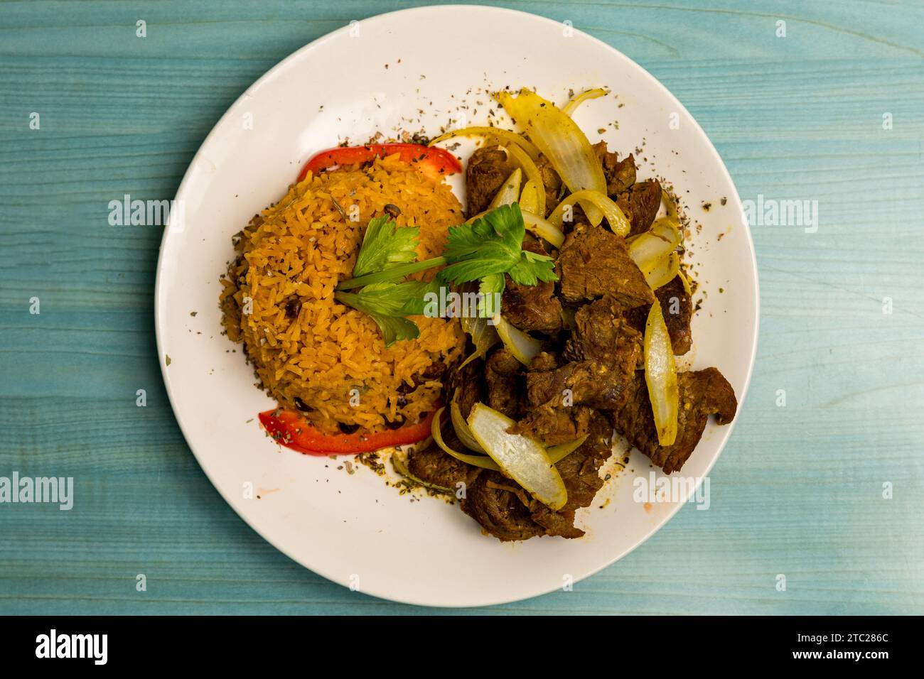 Steak and onions with yellow rice Stock Photo - Alamy