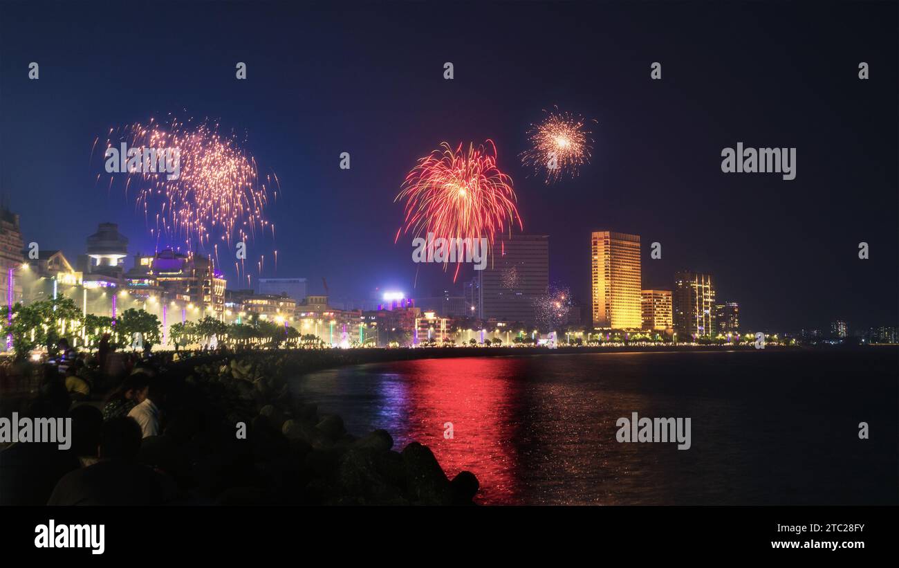 Illuminated City Skyline with Bursting Fireworks over the Water Stock Photo
