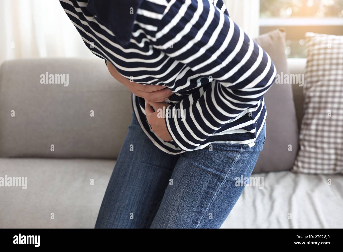 young woman suffering from stomach pain at home, closeup. food
