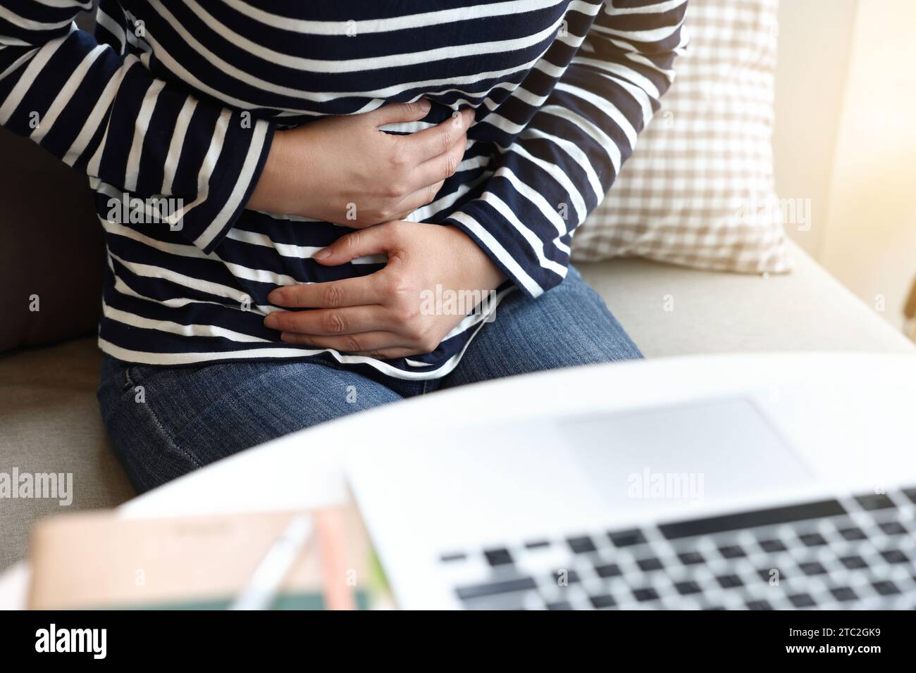 young woman suffering from stomach pain at home, closeup. food