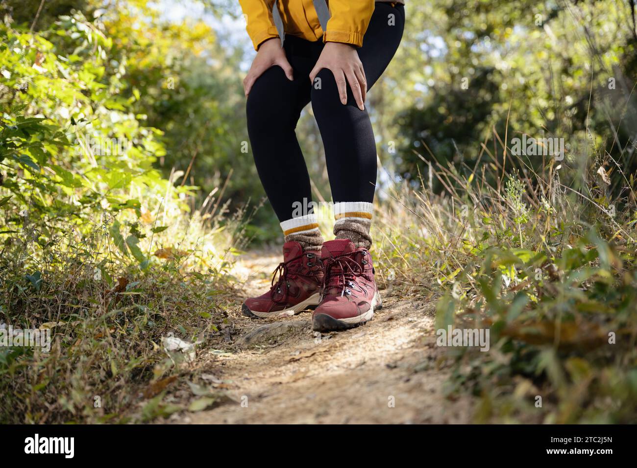 A woman is holding her knee joint in excruciating pain at a downhill