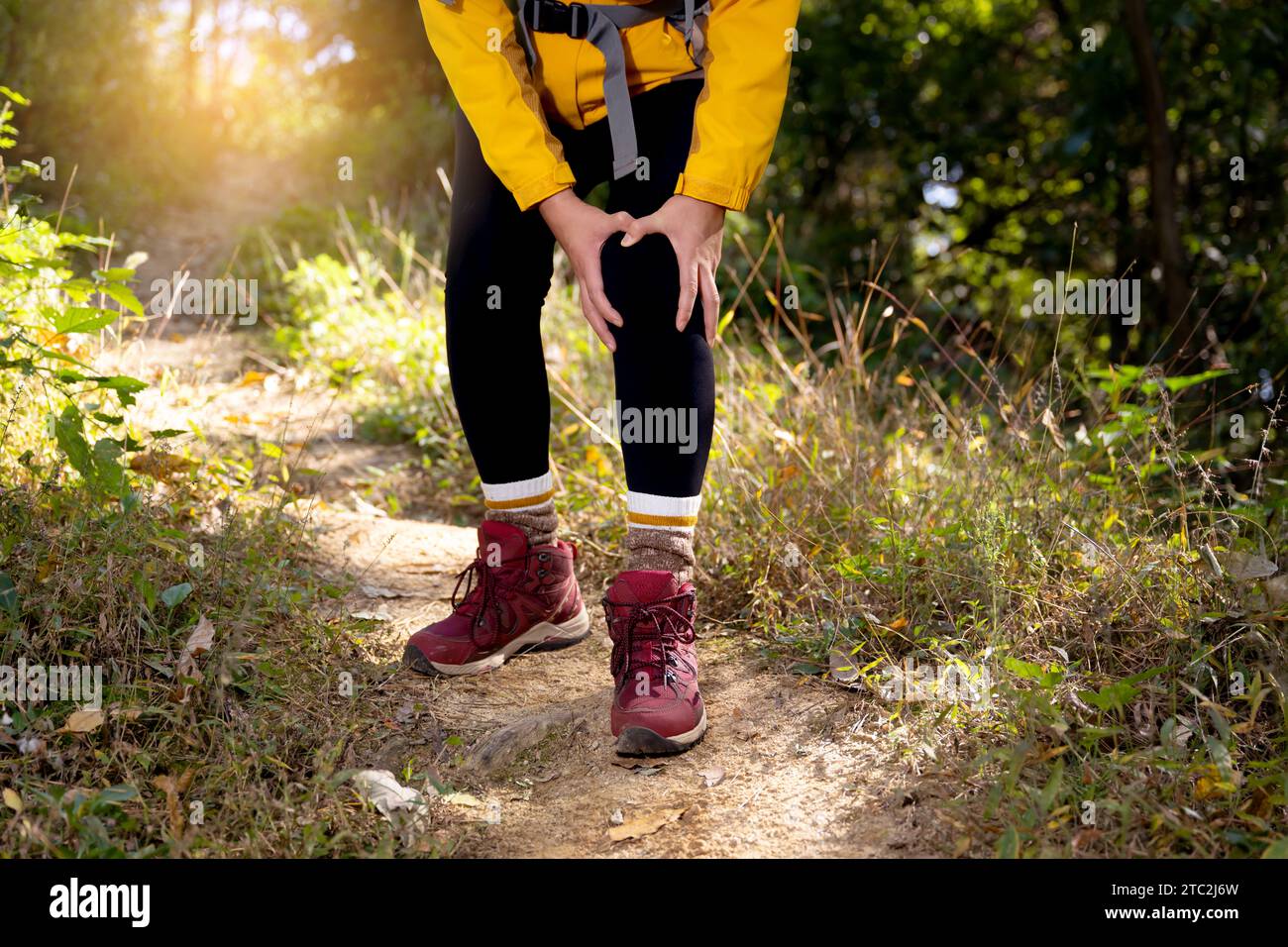 A woman is holding her knee joint in excruciating pain at a downhill