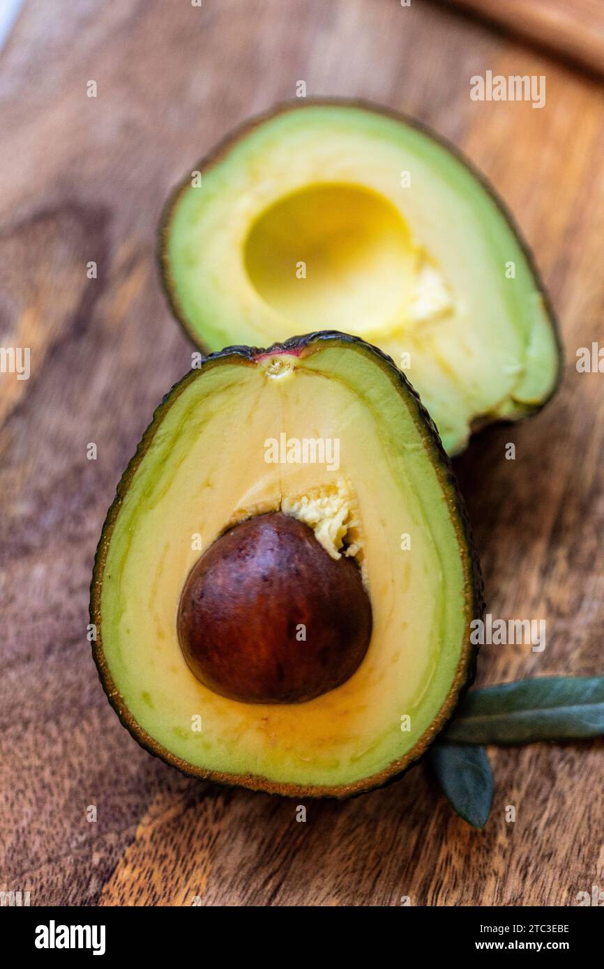 Close-up of a fresh and healthy avocado cut in half with pit, copy space Stock Photo