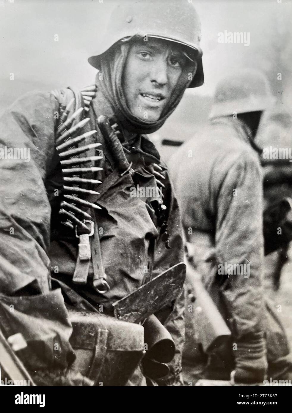 BATTLE OF THE BULGE   16 December  1944- 28 January 1945.  Still from a German film showing  a heavily armed soldier carrying a mortar plate in the Ardennes area of Belgium Stock Photo