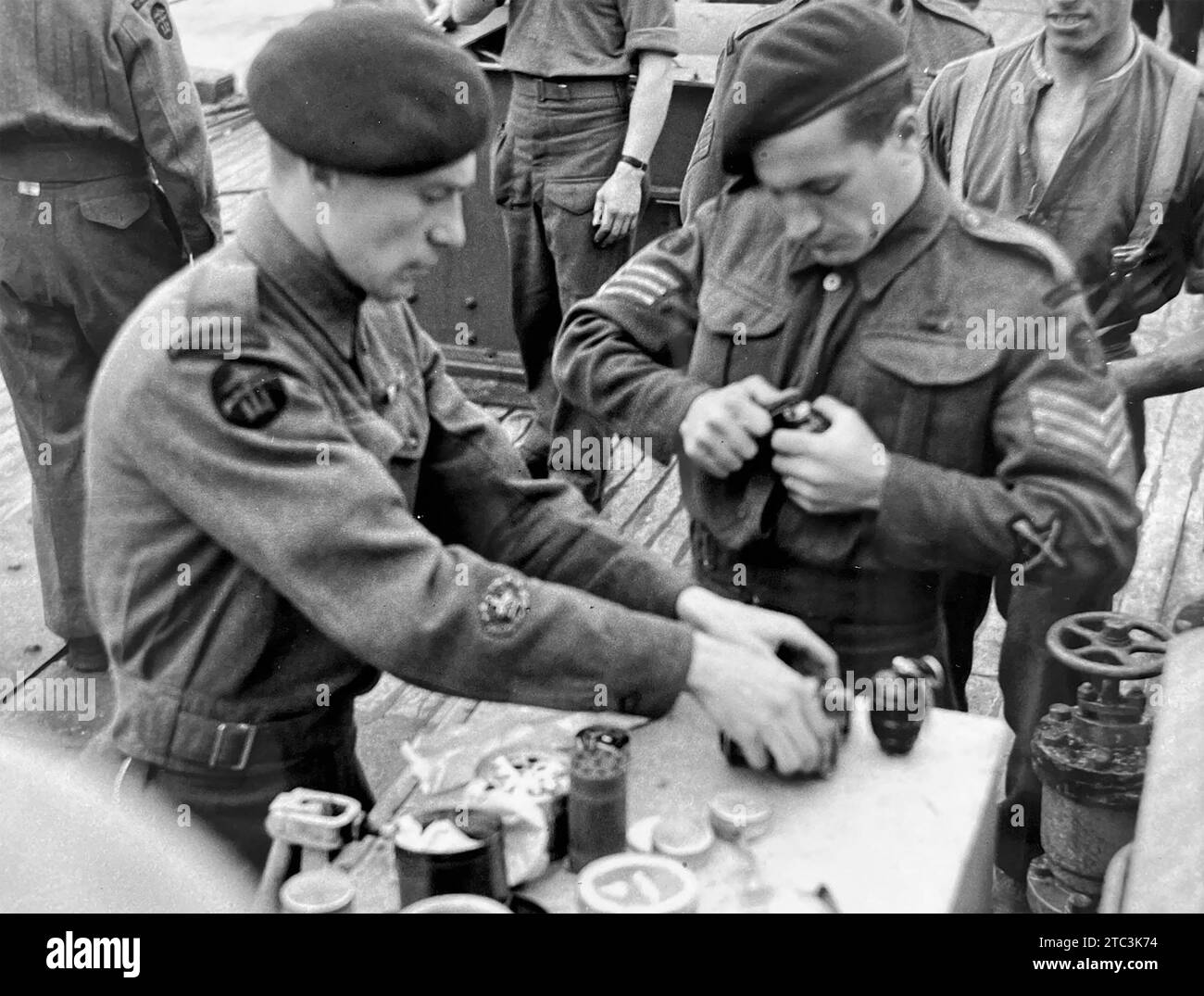 BRITISH COMMANDOS arming hand grenades prior to the Normandy landings in June 1944 Stock Photo